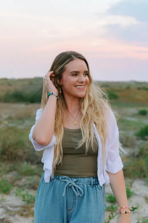 Ali looking thoughtfully off camera, outdoors at sunset