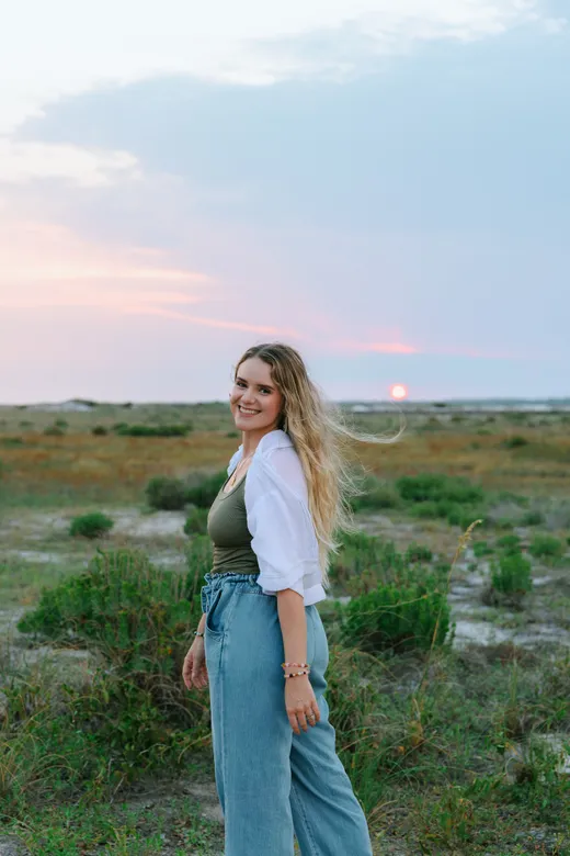 Ali smiling outdoors at sunset